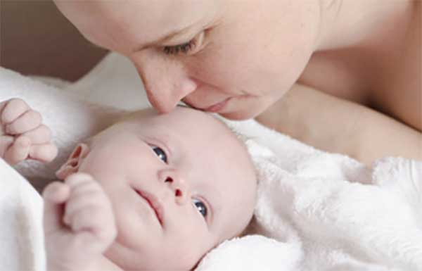 Бледный грудничок. Мама целует его лобик