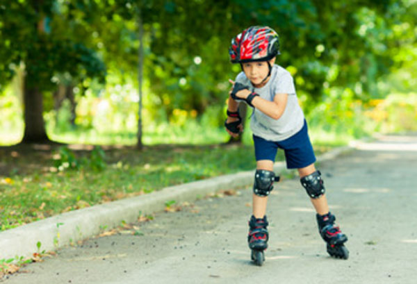 Мальчик едет на роликах. Средства защиты на нем одеты
