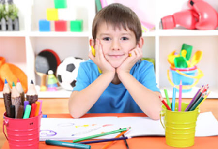 Задумчивый мальчик. Перед ним альбом и карандаши