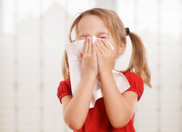 Девочка собирается чихнуть, прикладывает платок к носу