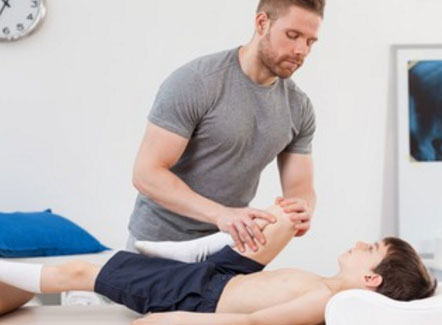 Специалист разминает мальчику ноги