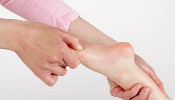 Специалист массирует ребенку стопу