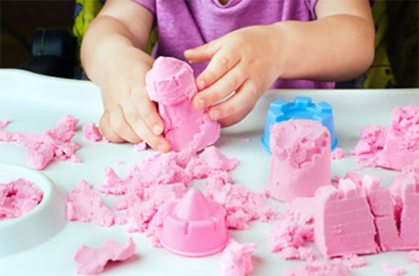 Девочка лепит паски из кинетического песка