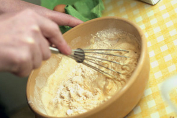 Женщина взбивает муку с желтком