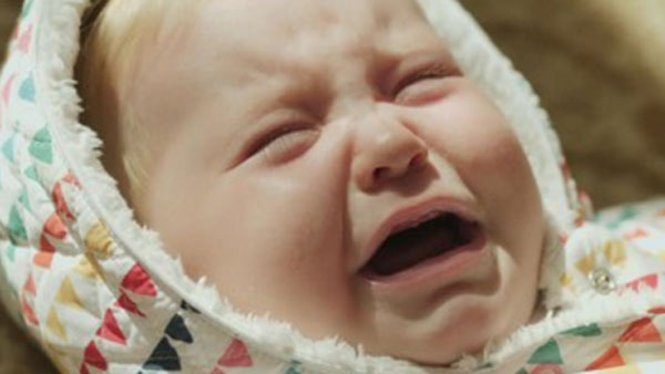 Плачущий грудничок в комбинезоне