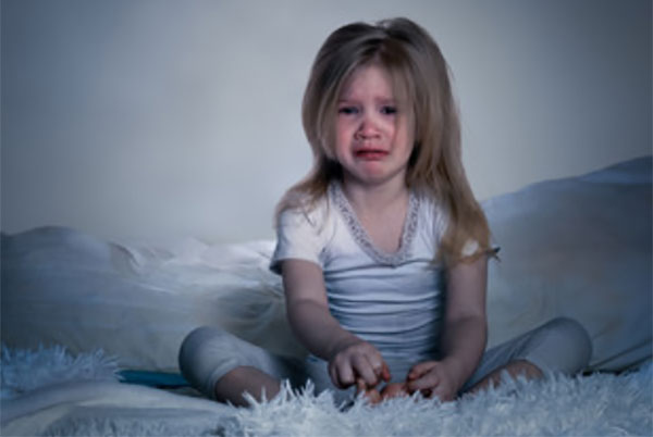 Девочка с неврозом сидит на кровати