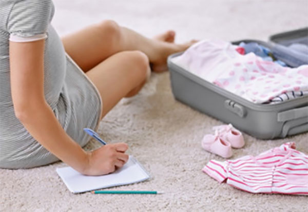 Беременная девушка собирает вещи в роддом