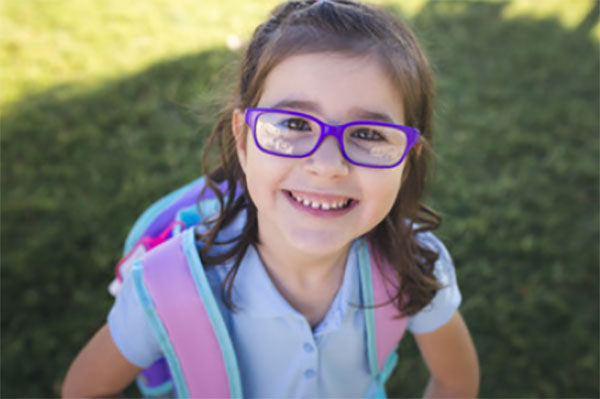 Счастливая девочка с рюкзаком за плечами