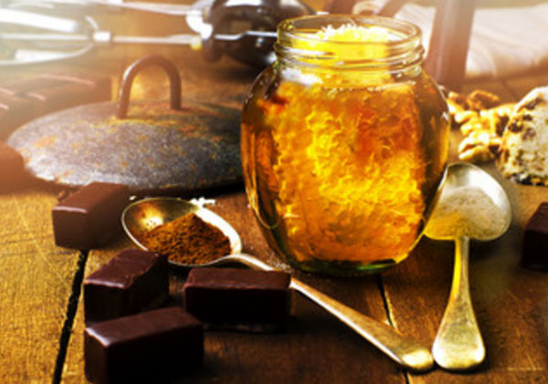 Баночка с медом. Рядом шоколадные конфетки