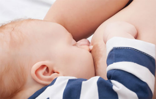 Ребенок сосет грудь, при этом щипает маму за нее