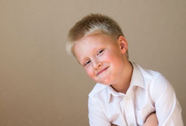 Мальчик со скрытой улыбкой, прячет руки под мышками