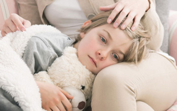 Девочка с красными щеками лежит на коленях матери