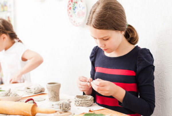 Девочка лепит вазочку