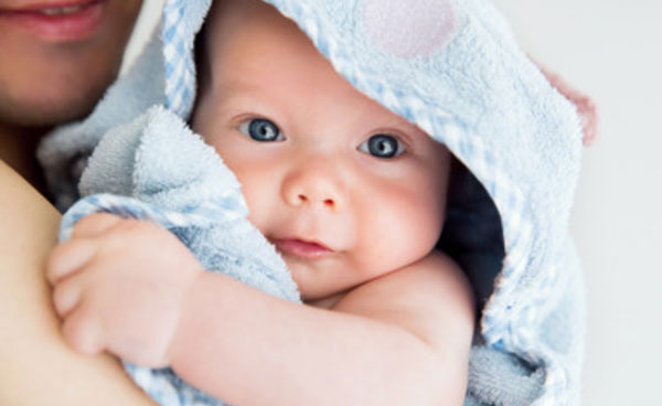 Ребенок у мамы на руках, замотанный в полотенце