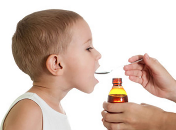 Мальчику дают сироп с ложечки