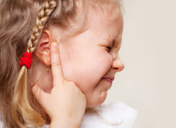 Девочка держится за ушко, ей больно