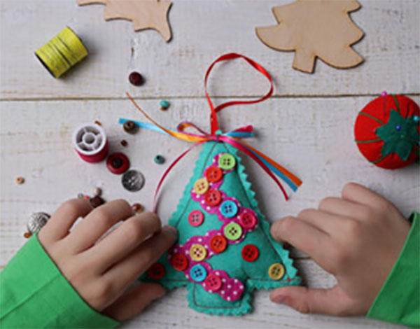 Мальчик делает из фетра елочку
