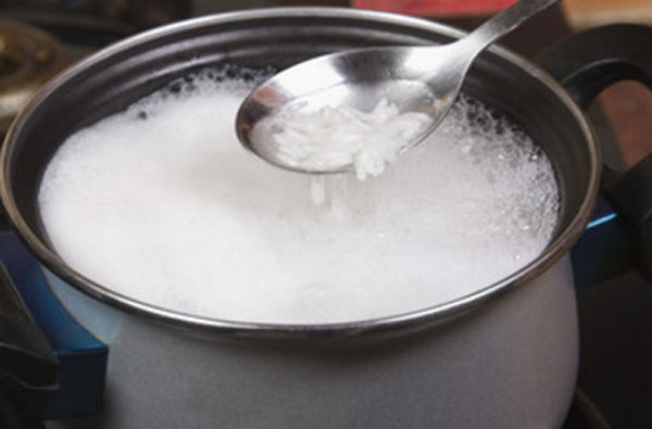 Рис с водой в кастрюле и на ложке