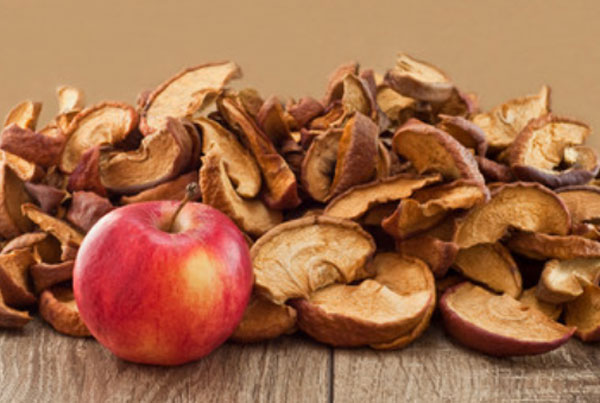 Свежее яблоко на фоне сушенных