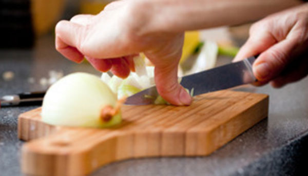 Женщина крошит лук