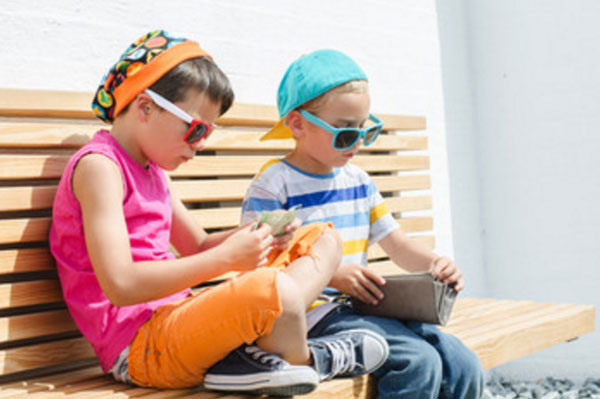 Мальчики сидят на скамейке, рассматривают, что есть в кошельке