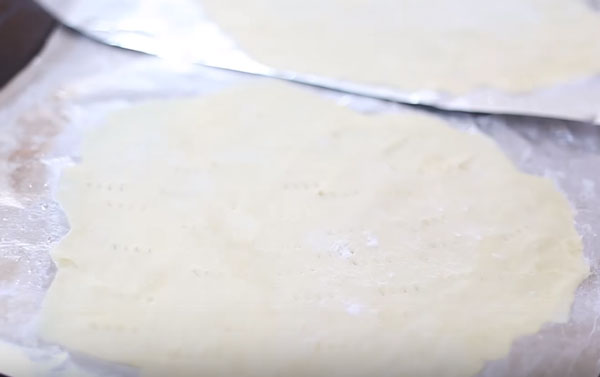 Сырой корж на противне, проколотый вилкой в нескольких местах