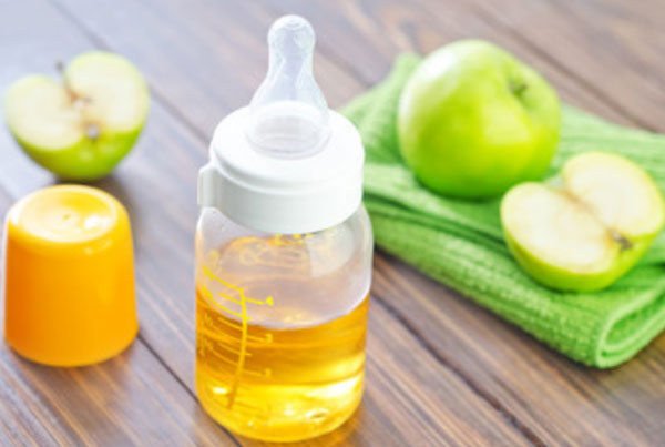 Бутылочка с яблочным соком. Зеленое яблоко, разрезанное по полам