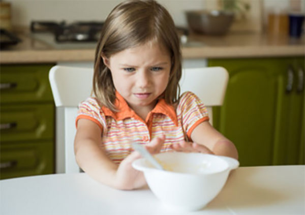 Девочка отодвигает тарелку с едой