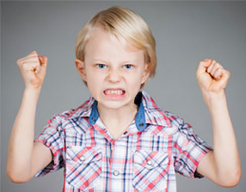 Мальчик замахивается двумя руками, хочет ударить