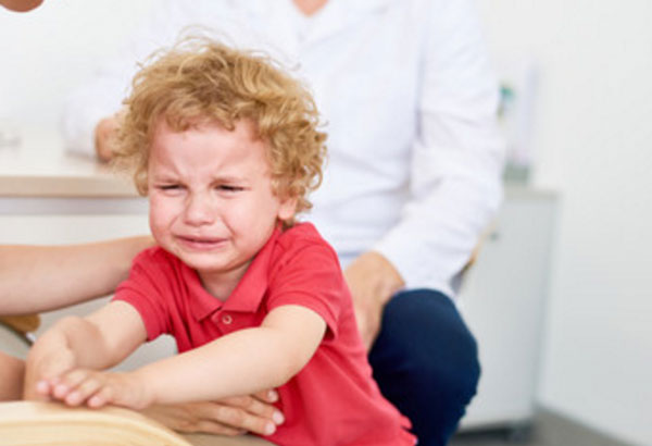 Мальчик в красной футболке всхлипывает. рядом родители