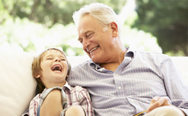 Мальчик сидит вместе с дедушкой. Они смеются