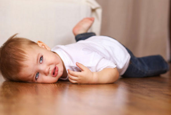 Обиженный ребенок лежит на полу. На глазах слезки