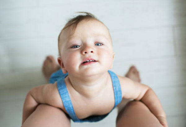 Малыш держит маму за ноги. так он просит, чтоб его взяли на руки