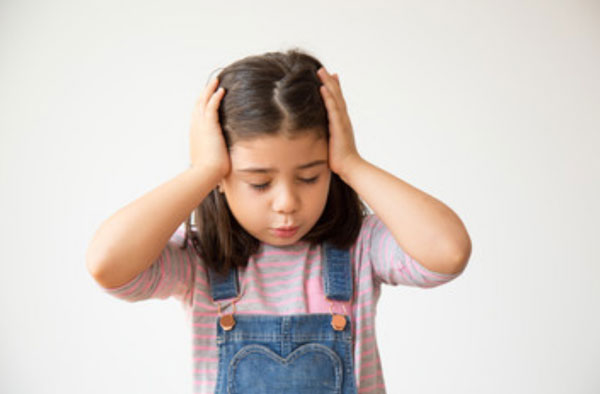 Девочка держится за голову
