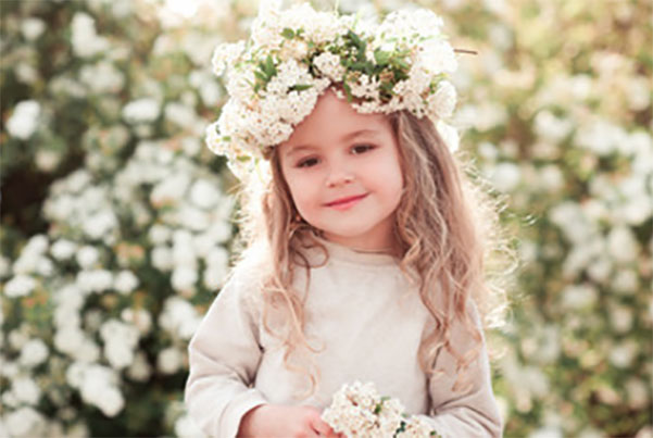 Трехлетняя девочка с красивым венком из цветов на голове