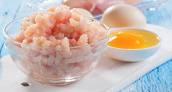 Куриный фарш в миске, рядом маленькая мисочка с разбитым яйцом