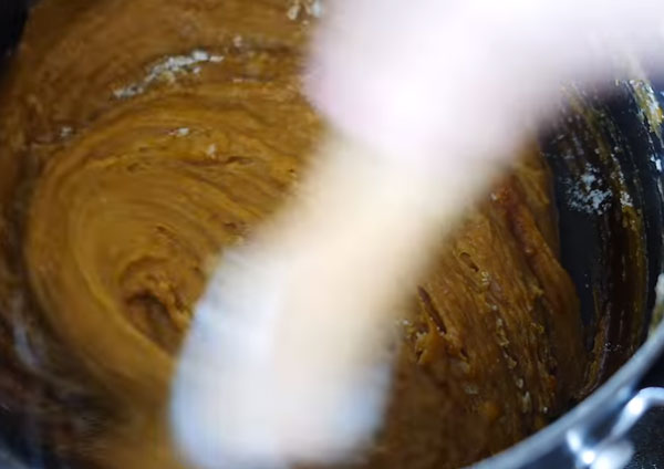 Тесто вымешивают на плите. Оно уже карамельного цвета