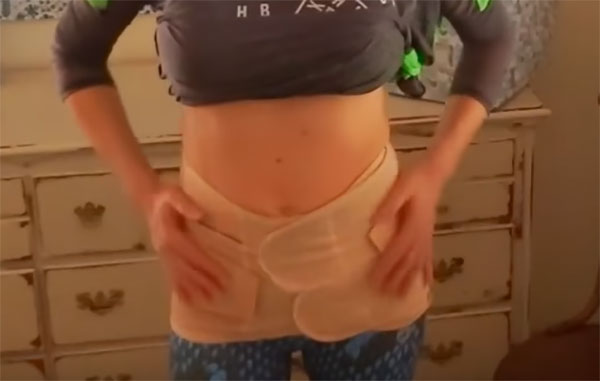 Женщина примеряет послеродовой бандаж