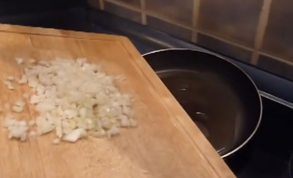 Пересыпание покрошенной луковицы на сковороду