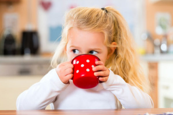 Девочка пьет из чашки