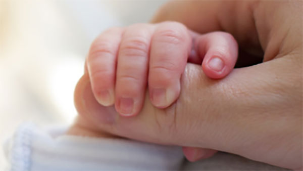 Ребенок держится за палец взрослого