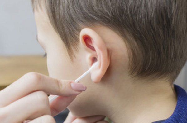Мальчику чистят уши ватной палочкой