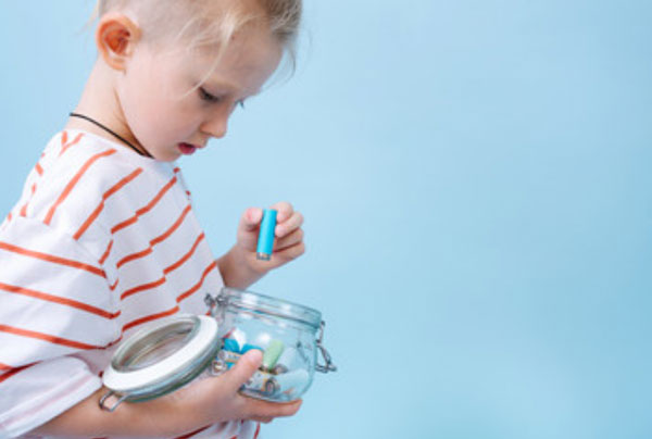 Ребенок достает батарейку из баночки