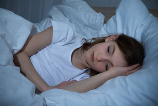 Девочка лежит в постели, не может уснуть