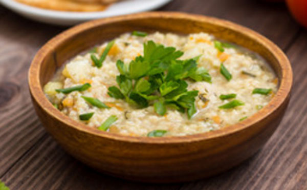 Пшеничная каша с мясом и морковью, украшенная веточками петрушки
