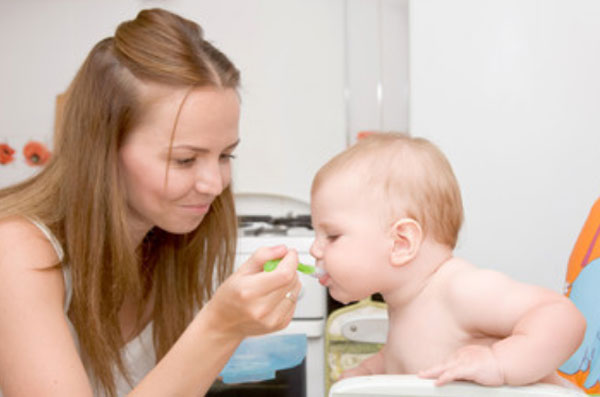 Грудничок пьет сок с ложечки