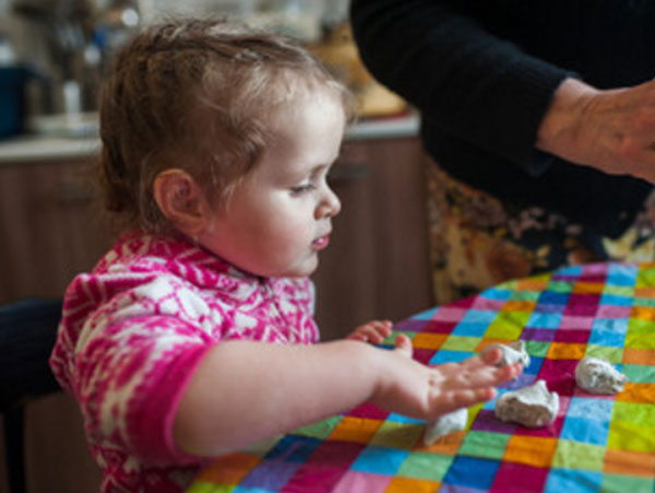 Девочка играет с кусочками теста