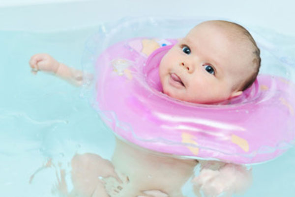 Ребенок в воде. На шее у него специальный круг