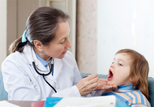 Врач осматривает ротовую полость ребенка