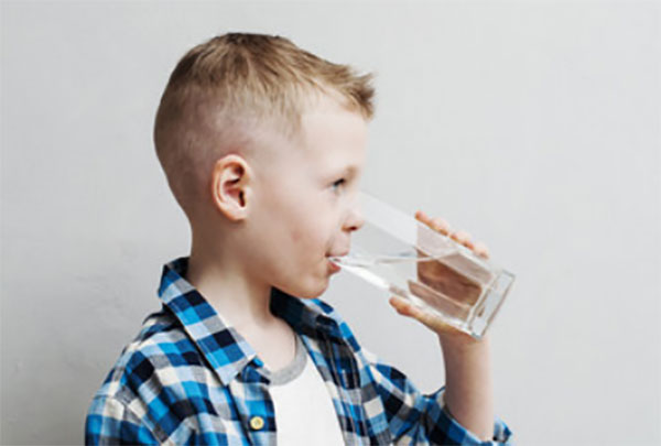 Мальчик пьет воду из стакана